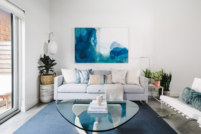penerapan biru pada ruang melalui lukisan abstrak serta karpet di ruang keluarga / breathe design studio